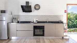 Eine moderne Küche mit Einbauofen, Mikrowelle und Kaffeemaschine.