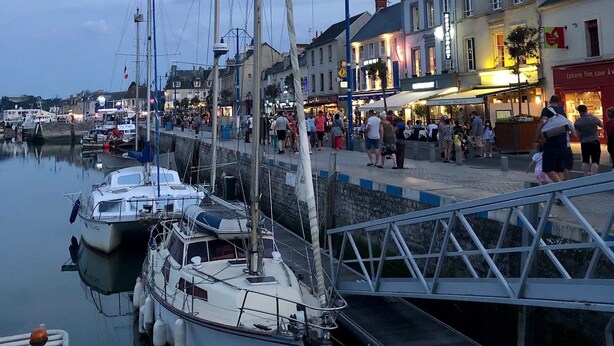 A marina with several boats docked, a pedestrian walkway, and buildings with shops and restaurants. - Luxury living in the heart of Normandy (Port-en-Bessin-Huppain)