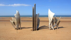 A beach with abstract metal sculptures and a clear view of the ocean. - Luxury living in the heart of Normandy (Port-en-Bessin-Huppain)