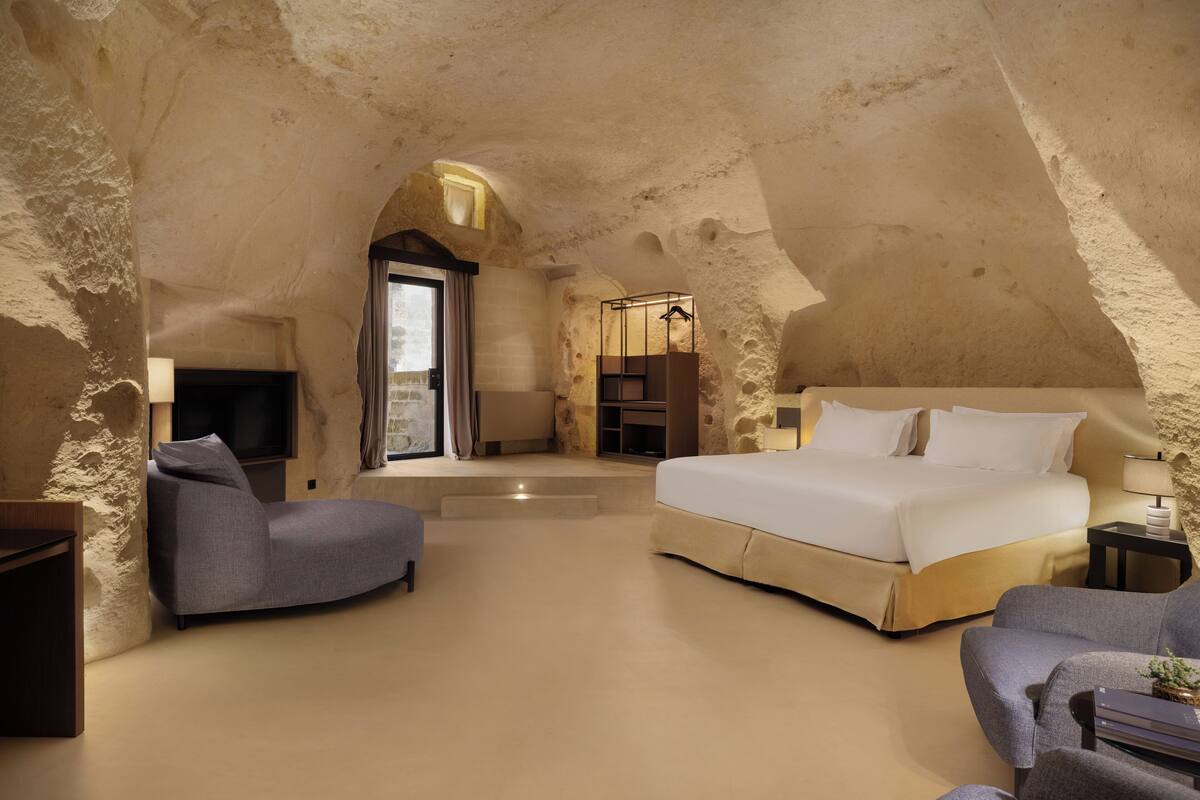 Une chambre avec un grand lit, un canapé et une télévision.