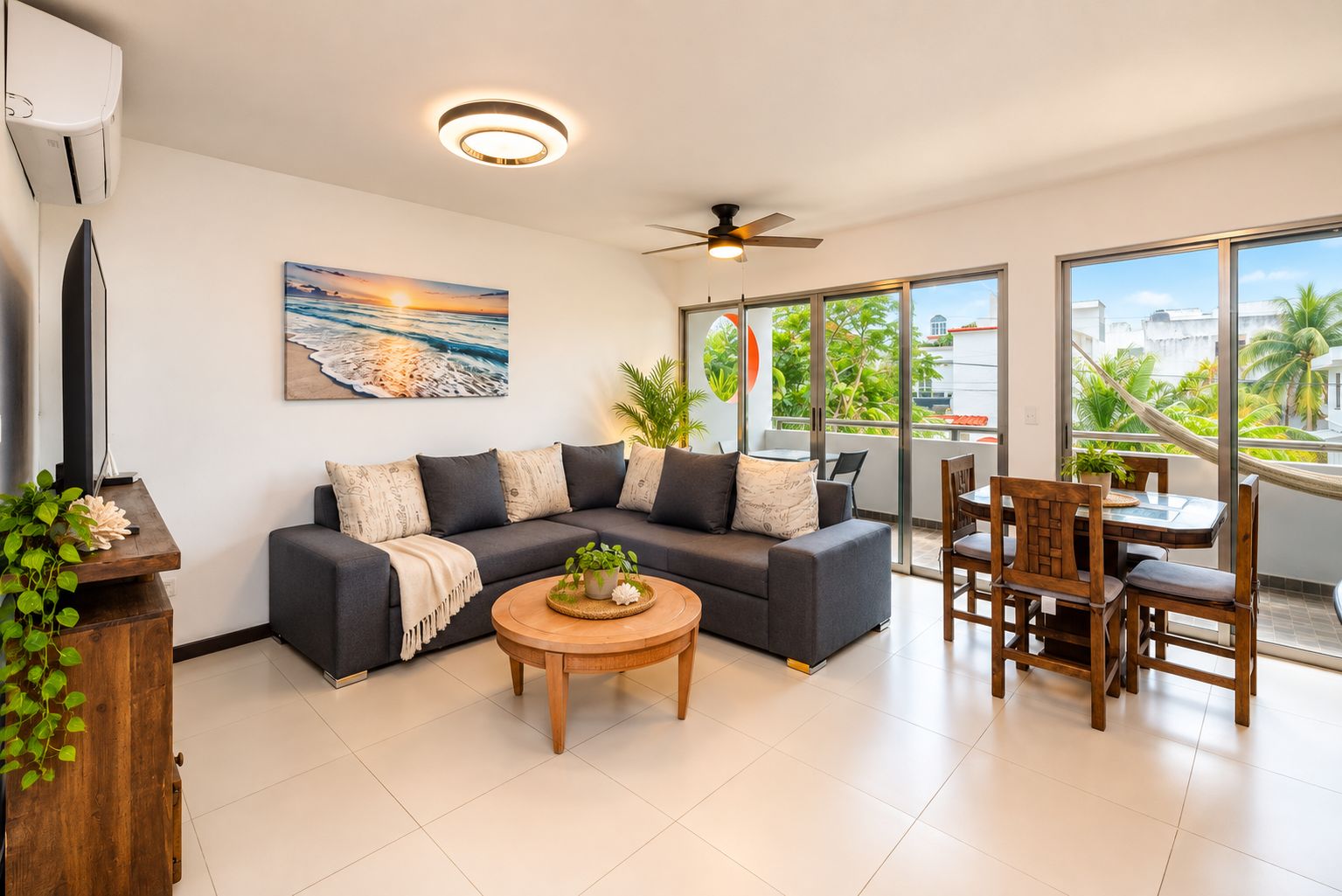 A modern living room with a sectional sofa, a coffee table, and a dining area with wooden chairs.