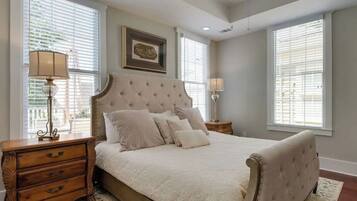 A bedroom with a large bed, two bedside tables, and a headboard.