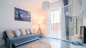 Ein modernes Wohnzimmer mit einer Couch, einer Lampe und einem Gemälde an der Wand.