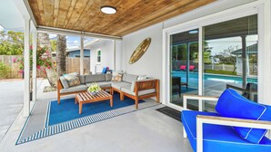 A covered patio with a wooden ceiling, a sofa set, a coffee table, and a pool view. - Tropical Oasis •Pet-Friendly + Pool Clearwater (Largo)