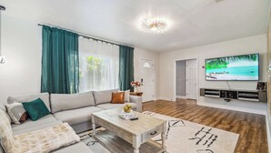 Een moderne woonkamer met een bank, salontafel en een flatscreen televisie.