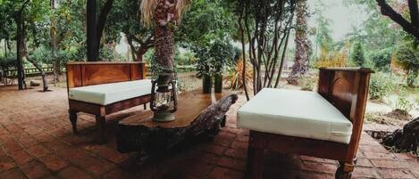 An outdoor seating area with two wooden benches and a lantern.