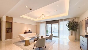A modern living room with a sofa, chairs, a coffee table, and a large window. - Luxurious 3BR, Full Burj Khalifa & Fountain view (Dubai)