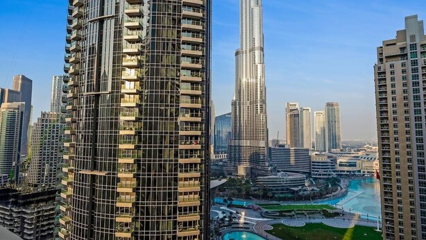 A modern high-rise building with a curved facade and multiple balconies. - Luxurious 3BR, Full Burj Khalifa & Fountain view (Dubai)