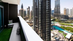 A high-rise building with a modern design, featuring a balcony with a view of the cityscape and a pool area. - Luxurious 3BR, Full Burj Khalifa & Fountain view (Dubai)