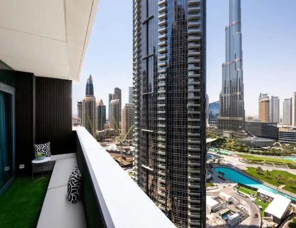 Un immeuble de grande hauteur au design moderne, doté d’un balcon offrant une vue sur le paysage urbain et d’un espace piscine.