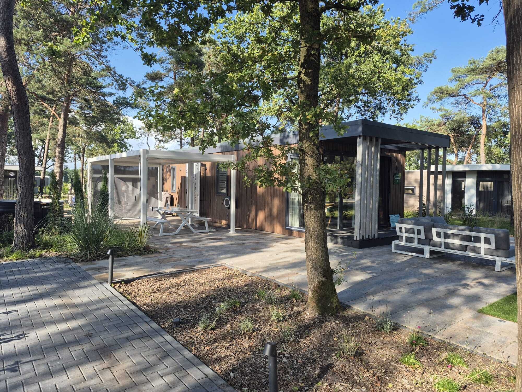 Un patio exterior moderno con zona de estar cubierta, una mesa de picnic y una terraza de madera.
