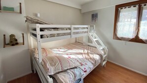 A bunk bed with a lower bunk, a shelf with a teddy bear, a window with curtains, and a small picture on the wall. - 06CO : beautiful apartment at the foot of the slopes with balcony (Guillaumes)