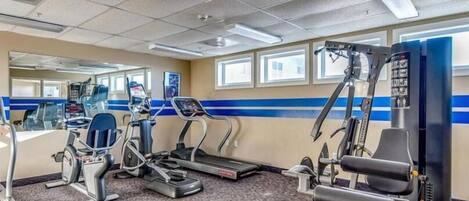 A gym with treadmills, elliptical machines, and weight machines.