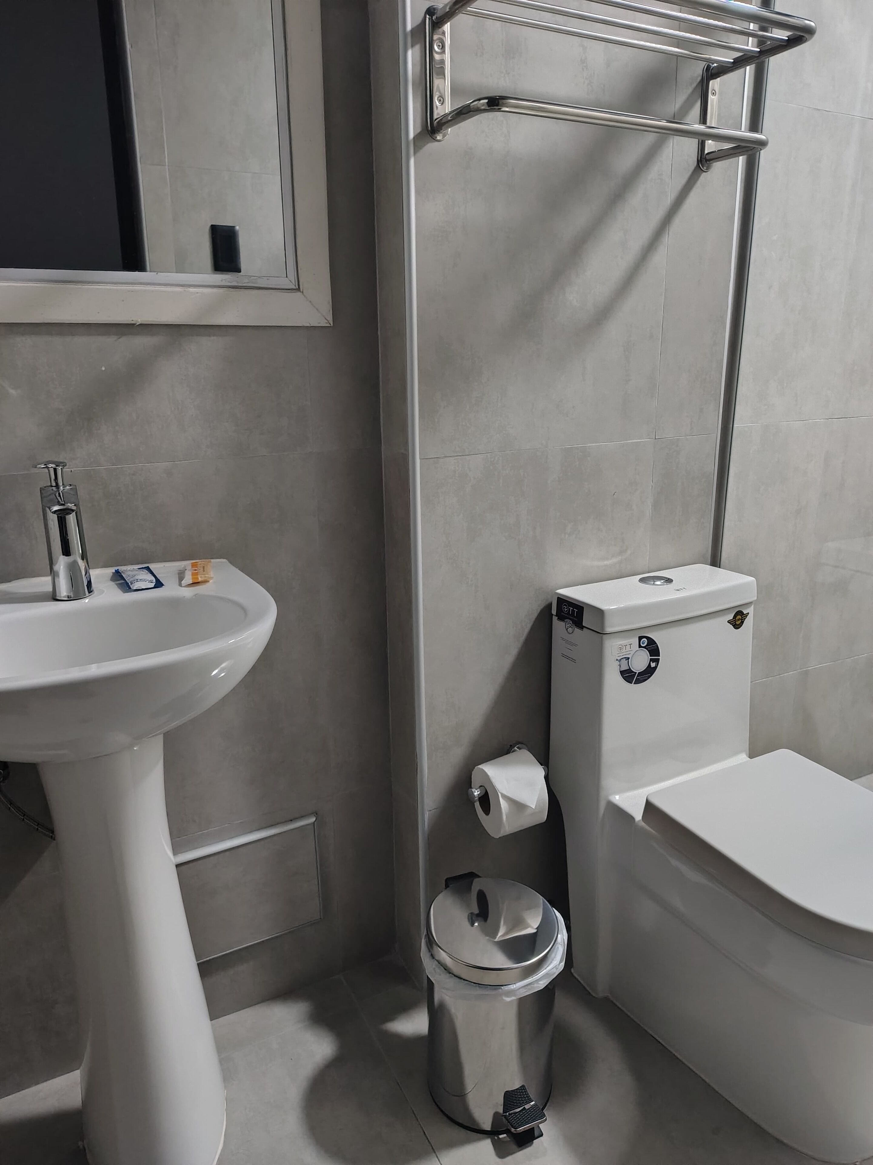 Ein modernes Badezimmer mit Waschtisch, Toilette und Mülleimer.