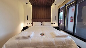 A hotel room with a large bed, a wooden ceiling, and a window with a fire extinguisher. - HOTEL EL CASTOR UCHUYACU HUARAZ (Tarica)