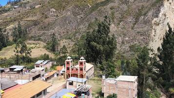 A hillside village with traditional buildings, a prominent church with two towers, and a mix of residential and commercial structures.