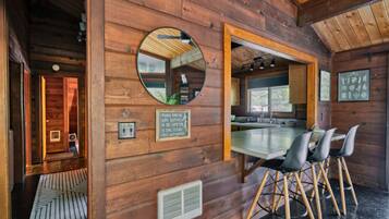 A wooden interior with a dining area, a mirror, and a sign instructing to turn on both switches to sync ceiling fans with remote.