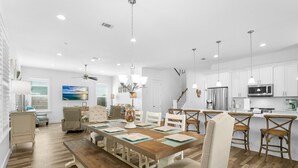 A modern kitchen with white cabinets, stainless steel appliances, and pendant lighting. - Sandy Toes Retreat with LSV and Woodlands (Miramar Beach)