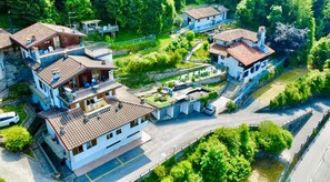 A residential area with multiple houses, a paved road, and a small body of water. - Paradise La Tana (Serina)