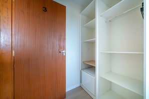 A wooden door with the number 3, adjacent to a white shelving unit with multiple compartments.