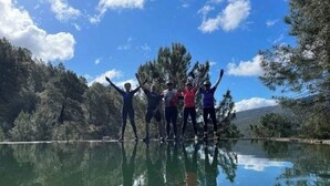 Four people standing on a reflective surface with trees and a clear sky in the background. - Hotel Rural Cristania (Caminomorisco)