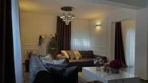 A modern living room with a dark-colored sofa, a marble coffee table, and a decorative chandelier. - Charming Holiday home with private pool,teniss field WiFi... Imotski,Croatia (Gornji Vinjani)