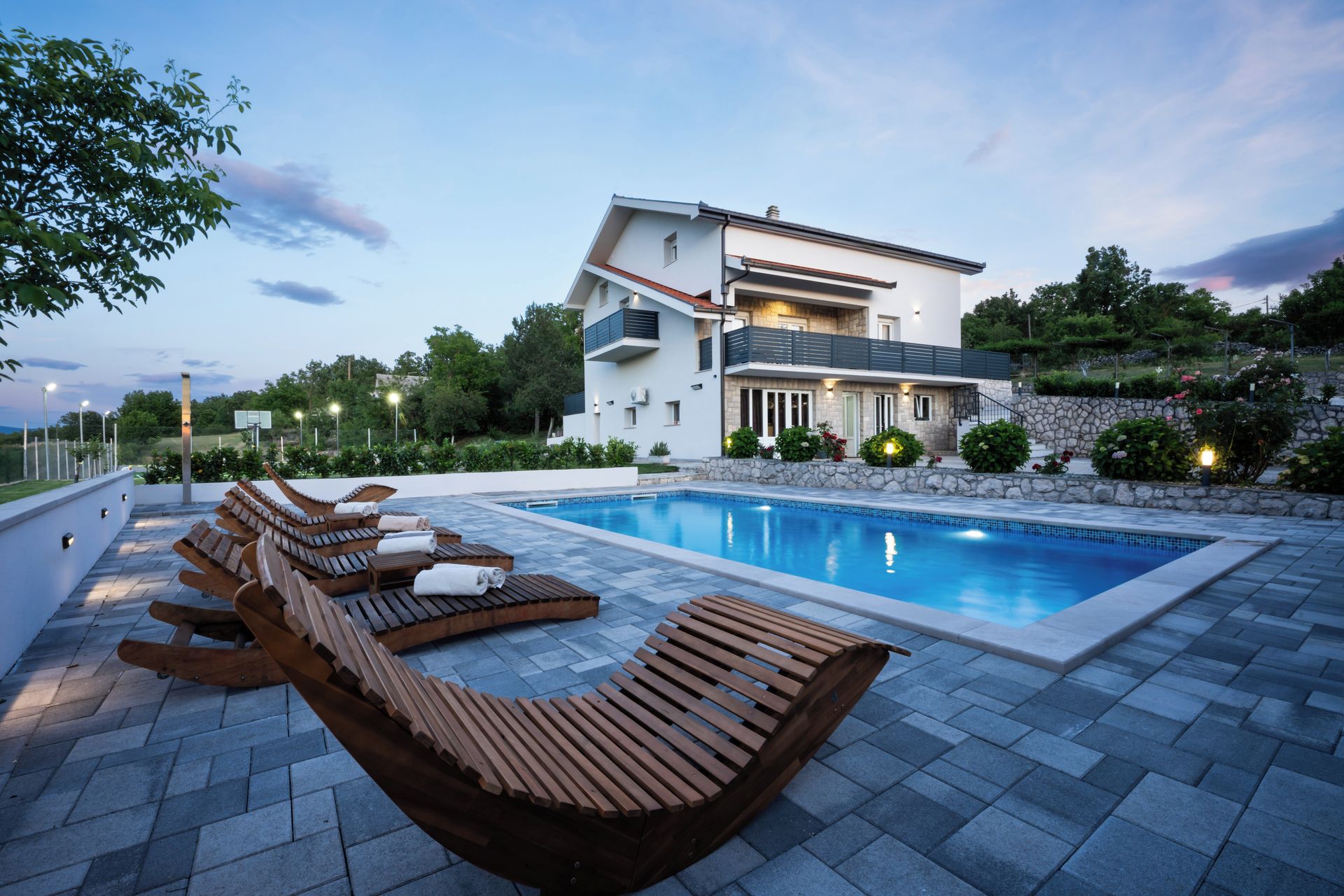 Un espace moderne aménagé au bord de la piscine, avec des chaises longues et une piscine.