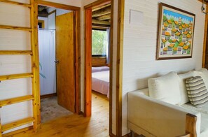 Cozy retreat with a sleeping area, sofa, and wooden flooring.