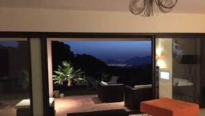 Ein modernes Wohnzimmer mit einem großen Schiebeglastür, die auf eine Außenpatio führt.