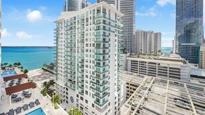 A high-rise hotel with multiple balconies, a pool area, and a view of the ocean. - Chic Brickell Condos – Prime Location (Miami)