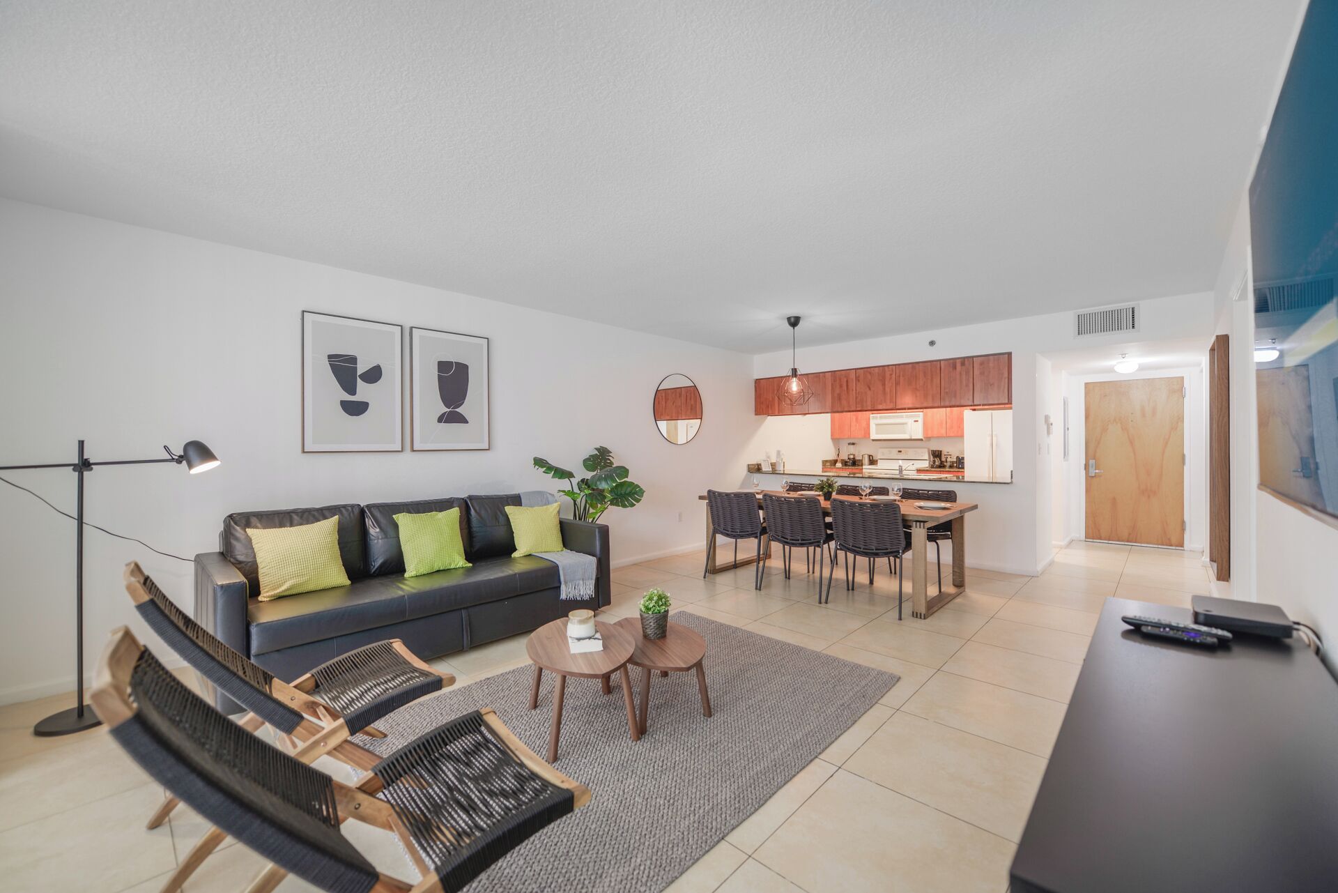 A modern apartment with a living room, dining area, and kitchen.