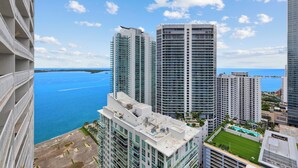 A high-rise building with multiple balconies overlooking a body of water. - Chic Brickell Condos – Prime Location (Miami)