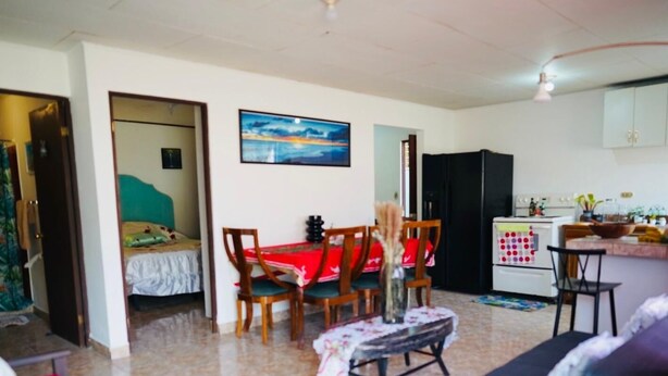 A compact living space with a dining area, kitchenette, and a bed.