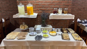 A buffet table with various food items, drinks, and condiments. - Kalenshen Calafate (El Calafate)