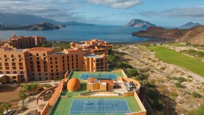Een resort met meerdere gebouwen, een tennisbaan en een golfbaan.