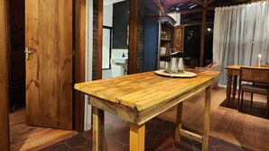 Una mesa de madera con suelo de baldosas hexagonales, una puerta de madera y una lámpara colgante.