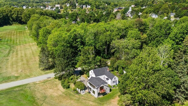 A large house surrounded by dense trees, with a well-maintained lawn and a clear sky. - Beauchamp Cottage, near Rockport Harbor and golf c (Rockport)