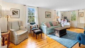 A living room with a sofa, armchairs, a coffee table, and a fireplace. - Beauchamp Cottage, near Rockport Harbor and golf c (Rockport)