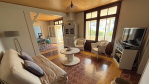 A spacious living area with a sofa, chairs, a coffee table, and a television. - Family home 300m from the beach  (Saint-Jean-de-Monts)