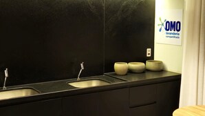 A modern bathroom with a black countertop, three sinks, and a wooden table. - Studio AD330 Alto da Boa Vista (São Paulo)