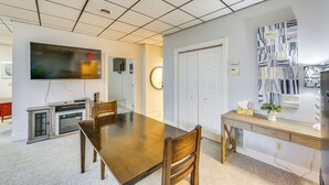 A conference room with a long table, chairs, a television, a fireplace, and a desk with a plant. - 1 Mi to Dtwn: Cozy Retreat in New Kensington! (New Kensington)
