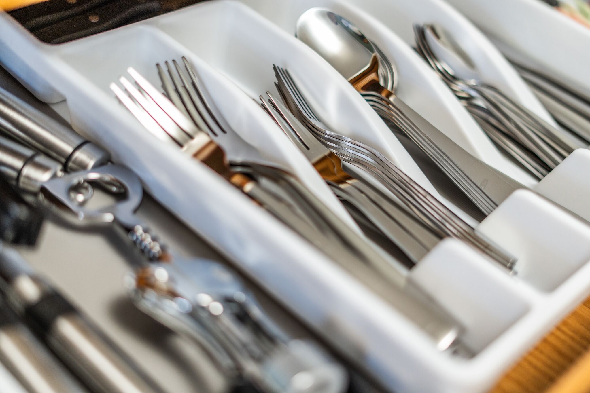 A close-up of a set of silverware neatly arranged in a compartmentalized tray.