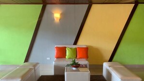 A modern lounge area with a sofa set, a coffee table, and a small potted plant. - Hotel Tijerinos (Boaco)