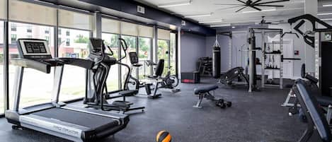 Academia com esteiras, bicicletas ergométricas e aparelhos de musculação.