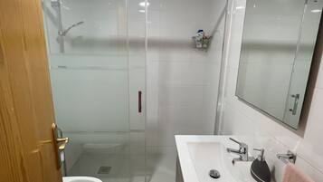 Een haardroger, handdoeken, zeep, toiletpapier