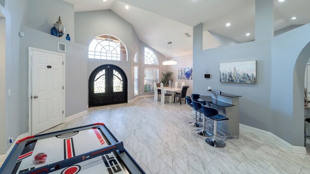 A spacious living area with a dining table, chairs, and a foosball table. - All Amenities of home! Centrally located, family friendly & ideal entertaining (Port St. Lucie)
