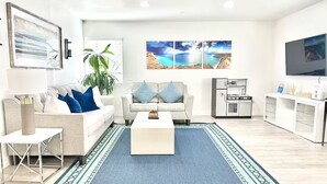 A modern living room with a sofa, coffee table, and a large rug. - Stunning Family Getaway - One Block from Beach, Fast WiFi, A/C, BBQ, Parking (San Diego)