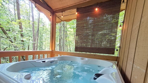 A hot tub on a wooden deck with a view of a forest. - Wildflower (Sautee Nacoochee)