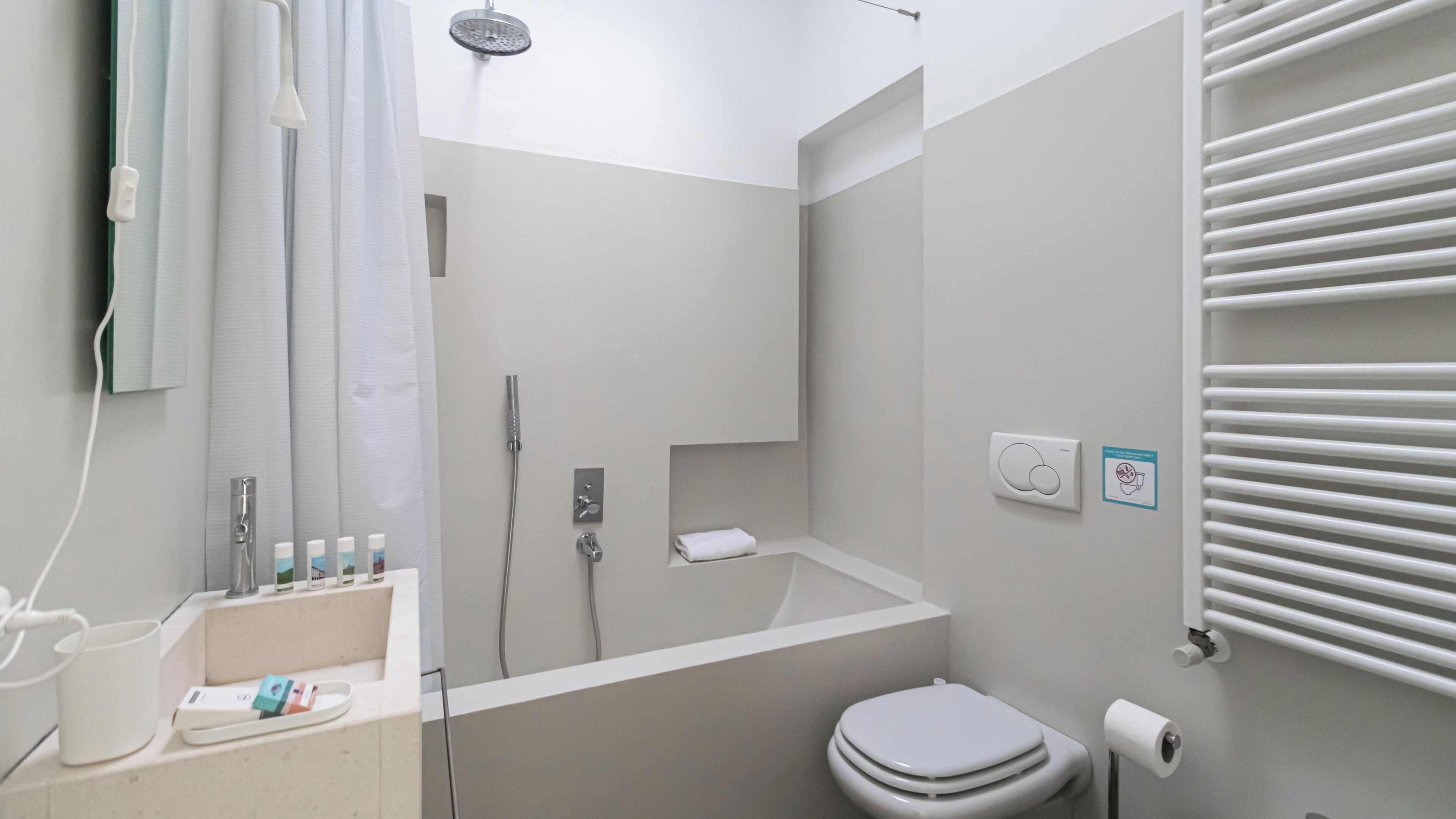 A modern bathroom with a shower, toilet, and sink.