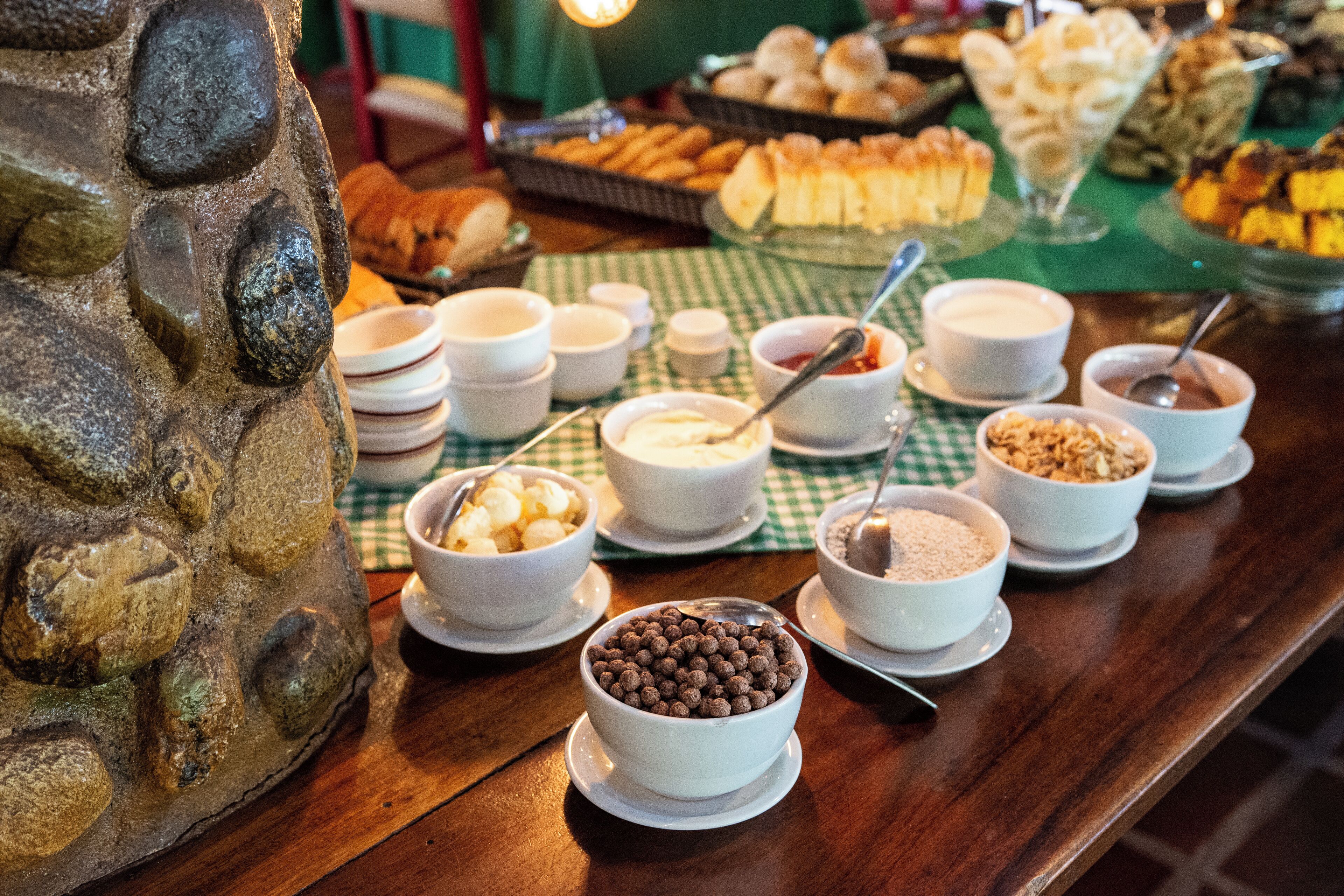 A buffet table with various food items and bowls.